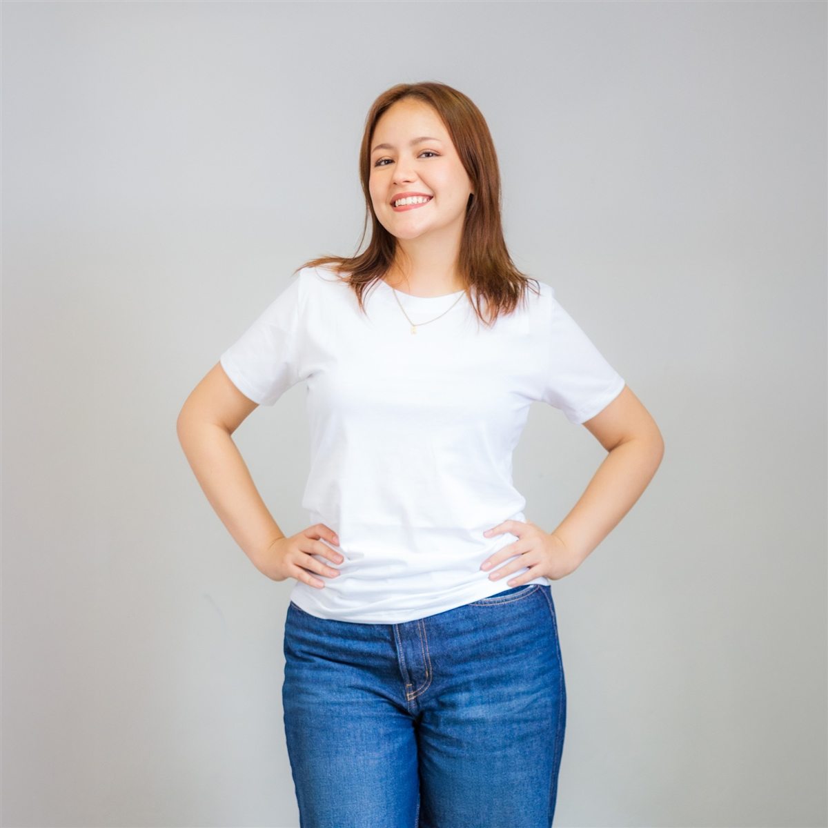 Modelo sonriente con polo básico blanco de dama y jean azul